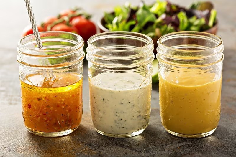 Three salad dressing in bottled jars. Three salad dressing in bottled jars.