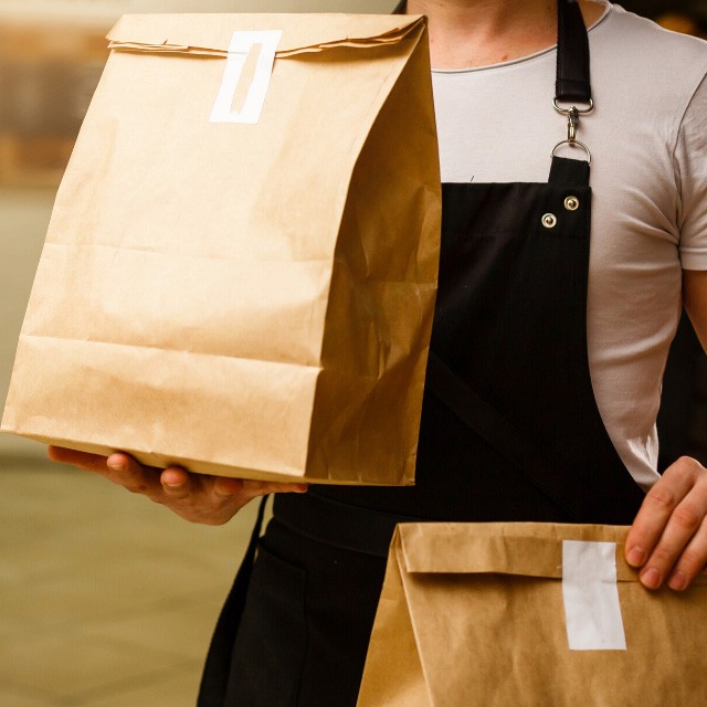 Restaurant staff holding food delivery package Restaurant staff holding food delivery package