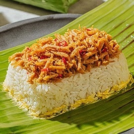 Chicken patir with shredded chicken over rice wrapped in banana leaf. Chicken patir with shredded chicken over rice wrapped in banana leaf.