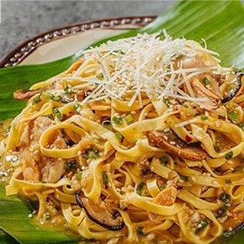 Garlic butter pancit with chicken and mushroom served on a banana leaf-lined plate. Garlic butter pancit with chicken and mushroom served on a banana leaf-lined plate.