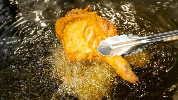 Fried chicken being deep-fried in hot oil. 