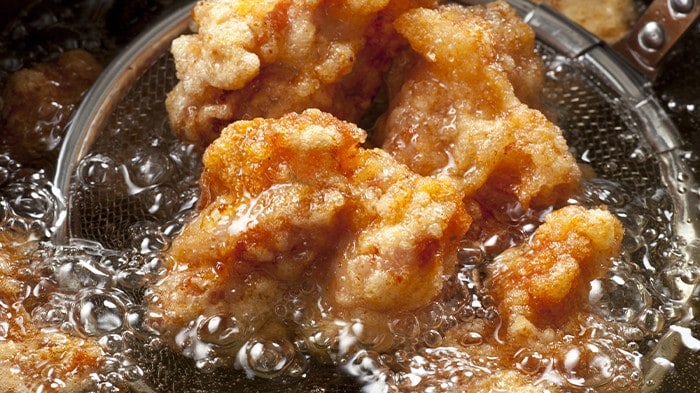 Japanese fried chicken being fried in oil. 