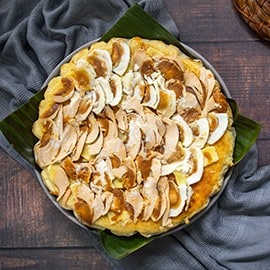 A large bibingka cheesecake on a silver platter. A large bibingka cheesecake on a silver platter.
