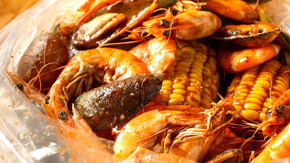 Seafood boil with shrimp, mussels, and corn in a plastic bag. 