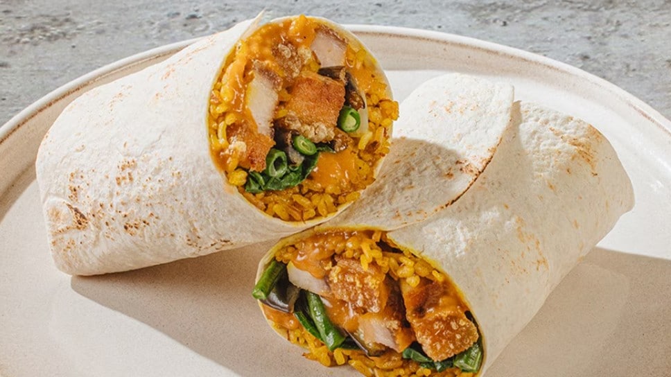 Lechon kawali kare-kare burrito on a white plate.