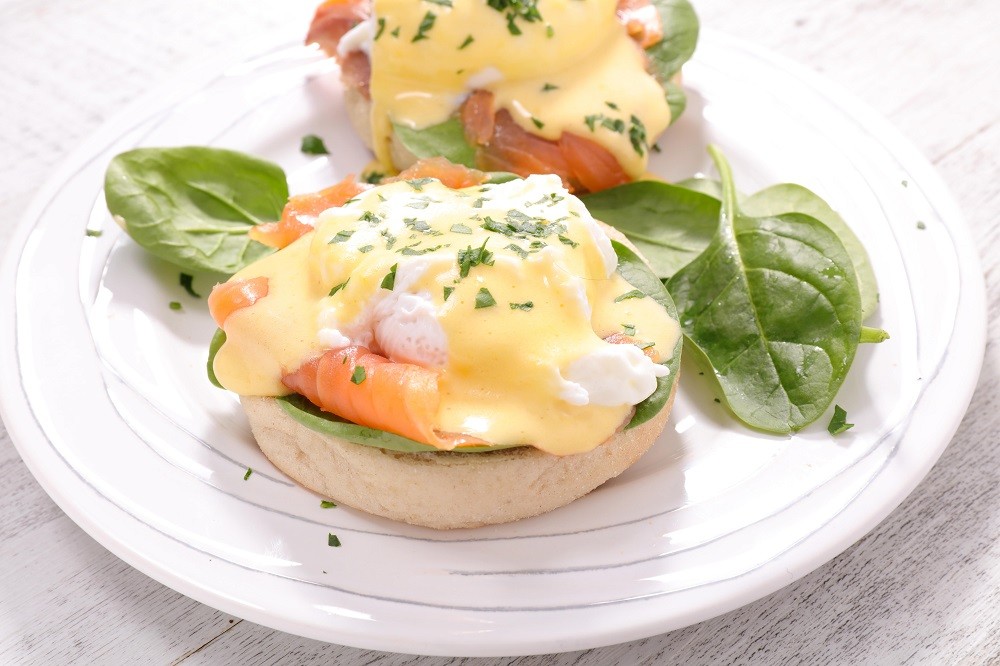 A plate of eggs benedict with smoked salmon smothered in hollandaise sauce A plate of eggs benedict with smoked salmon smothered in hollandaise sauce