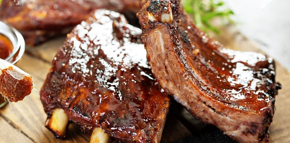Grilled pork ribs with barbecue sauce on the side. 