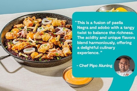 Adobong pusit paella with pickled mushrooms served with aioli and lemon slices. Adobong pusit paella with pickled mushrooms served with aioli and lemon slices.