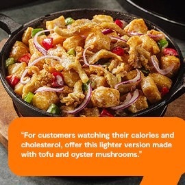 Tofu sisig with mushrooms on a sizzling plate. 