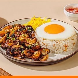 Soy-roasted mushrooms with garlic rice, fried egg, and atchara.