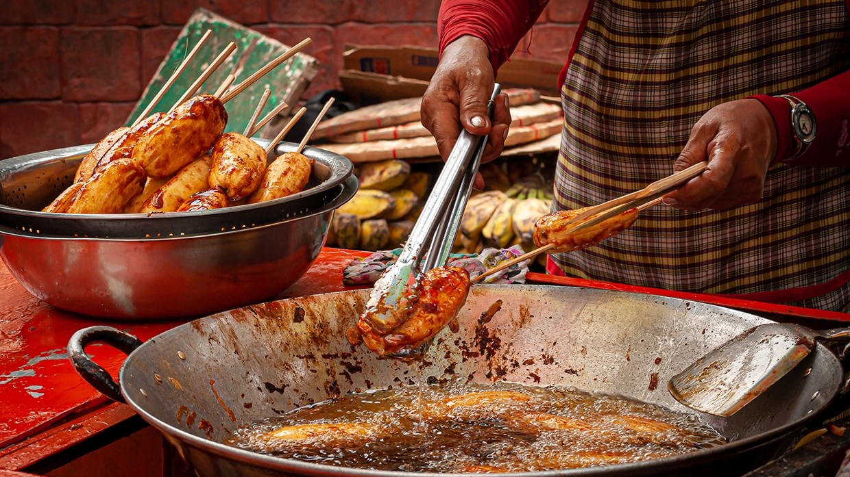 A cook preparing banana cue. A cook preparing banana cue.