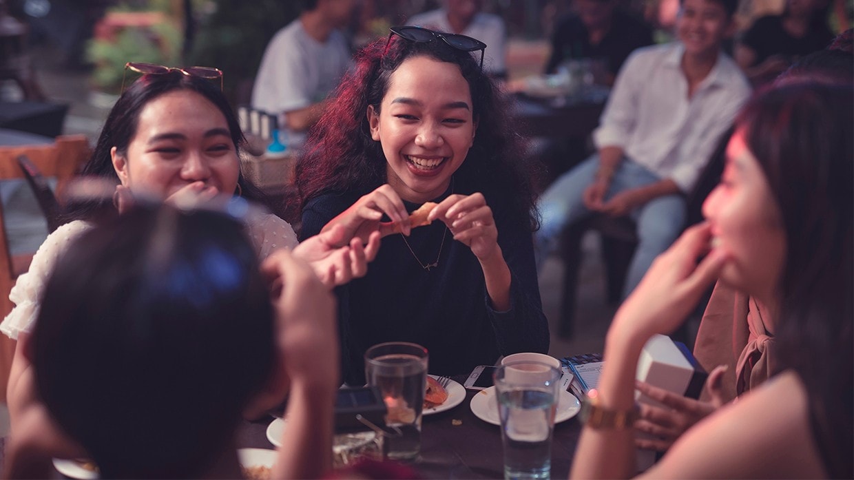 Young diners enjoying food and beverages outdoors. Young diners enjoying food and beverages outdoors.