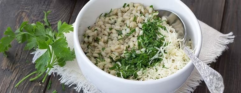 A bowl of cooked ancient grains tossed with fresh herbs and vegetables. A bowl of cooked ancient grains tossed with fresh herbs and vegetables.