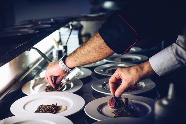 Plates of food being prepared by chefs in the restaurant kitchen