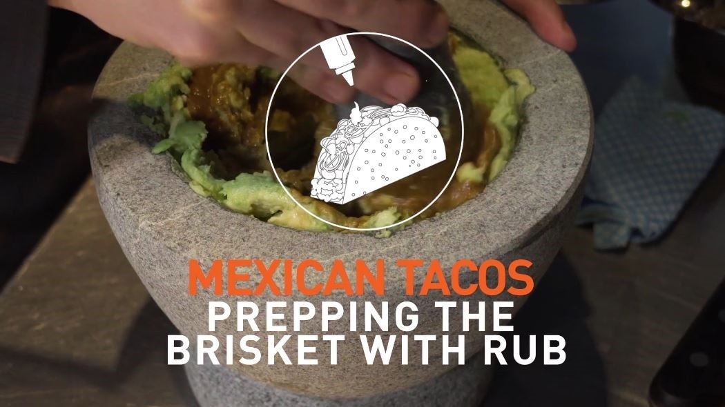 Bowl of guacamole with text that reads: Prepping the brisket with the rub.