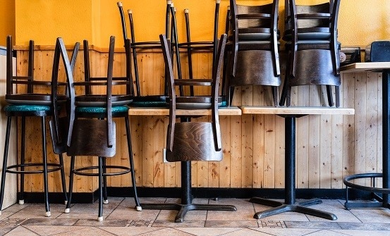 Restaurant chairs and tables stacked and set aside.