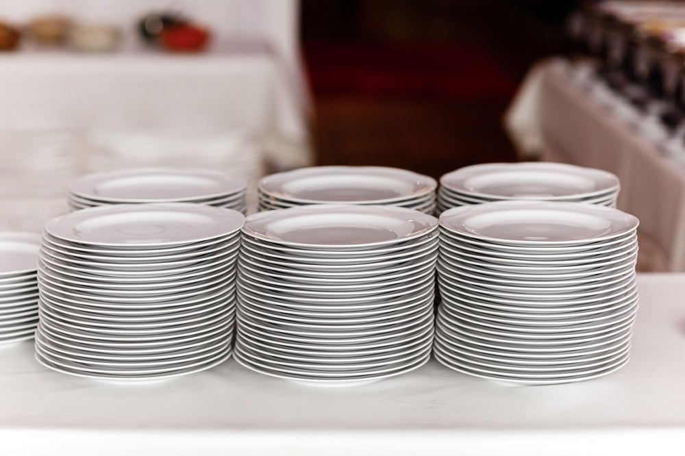 Stacks of clean plates sit on a buffet table Stacks of clean plates sit on a buffet table