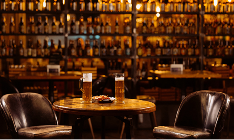 Interiors of a pub featuring a table with beer mugs. 