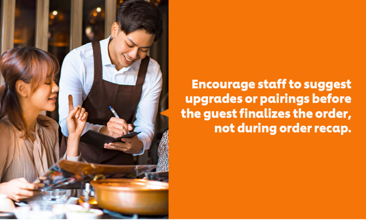 A waiter taking orders from female customers.