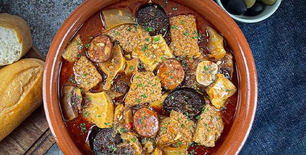 Callos Madrileños with chorizo and tripe in a clay bowl.