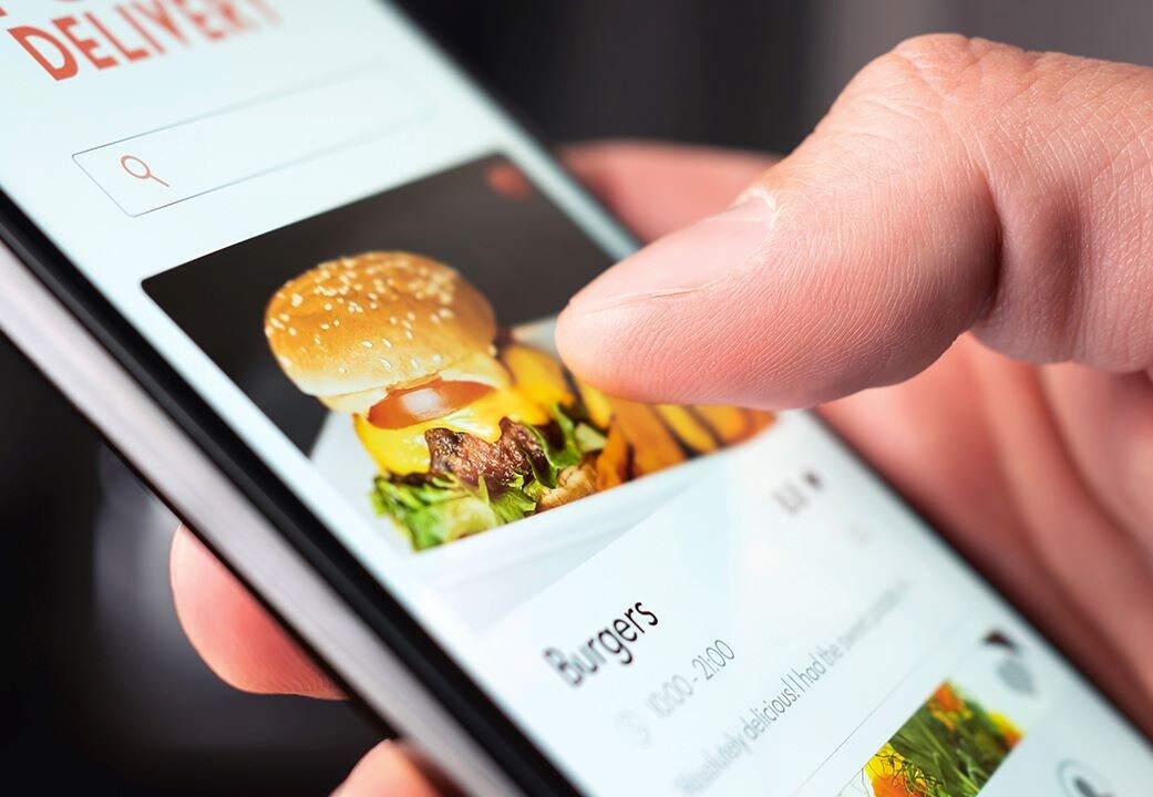 Phone with the delivery app and a burger Phone with the delivery app and a burger