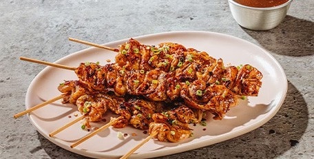 Chicken skin yakitori on an oval plate.