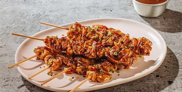 Chicken skin yakitori on an oval plate.