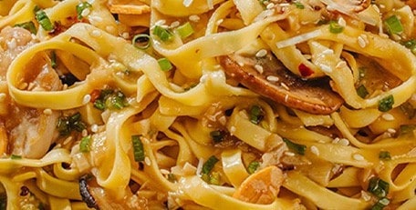 Garlic butter pancit topped with chicken and mushrooms.