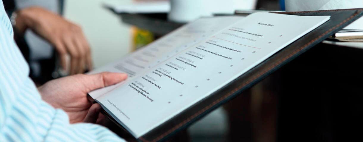 A person holding a restaurant menu. 