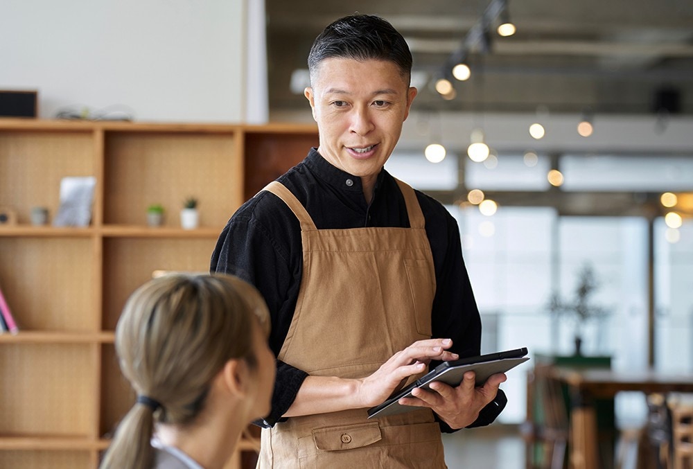 A waiter listening to a customer attentively. A waiter listening to a customer attentively.