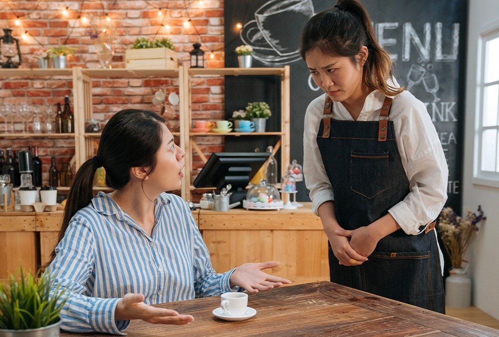 A waiter listening to a customer attentively. A waiter listening to a customer attentively.