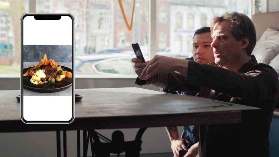 chef holding cellphone for food photography