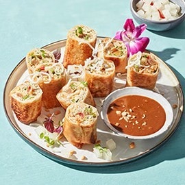 Modern lumpia rolls served with peanut sauce. Modern lumpia rolls served with peanut sauce.
