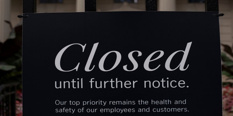 A closure sign on an establishment’s glass window A closure sign on an establishment’s glass window