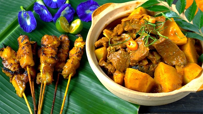 Chicken satti and beef curry served over a banana leaf. 